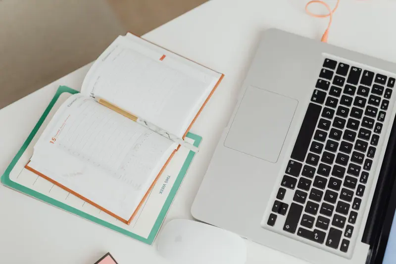 Open planner beside a laptop on a desk