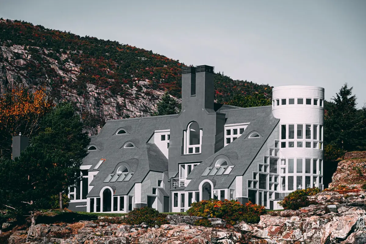 Contemporary house on a rocky hillside with autumn trees